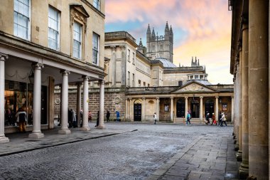 23 Ocak 2020 'de Bath Street, Bath, Somerset, İngiltere' de gün batımında Pump Room ve Bath Abbey 'e giden kolonileştirilmiş Gürcü binaları