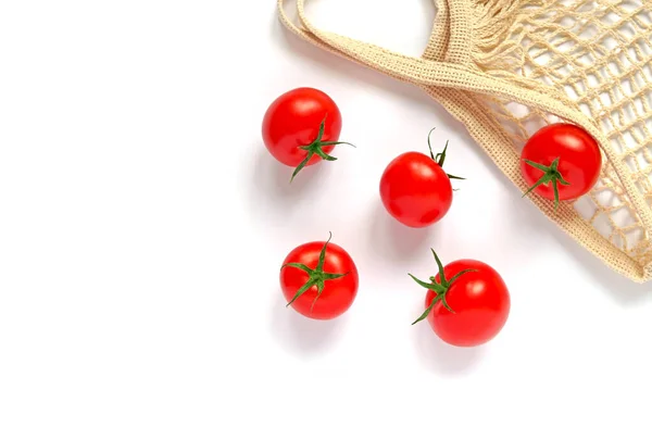Vista superior de cinco tomates vermelhos frescos com estacas verdes e um saco de cordas feito de material natural, sobre um fundo branco. Isolados . — Fotografia de Stock