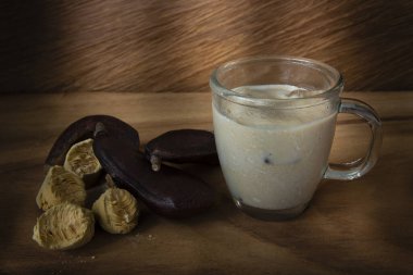 Ahşap bir arka planda keçiboynuzu suyu ve meyve suyu.