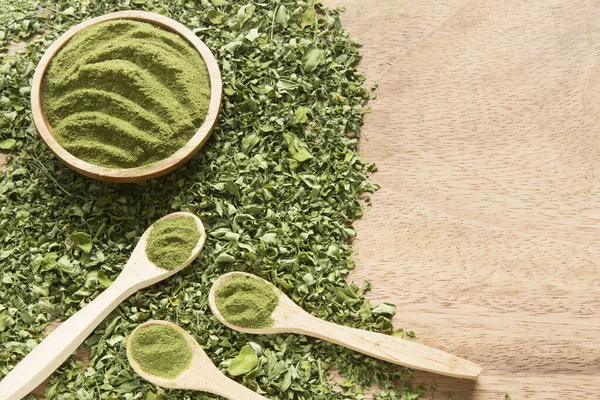 Moringa, ahşap bir arka planda yapraklar ve toz...