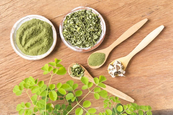 Moringa, yapraklar, tohumlar, tahta bir arka planda toz - Moringa oleifera