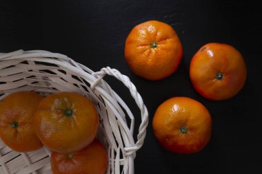 Clementine siyah arka planda sepetin içinde