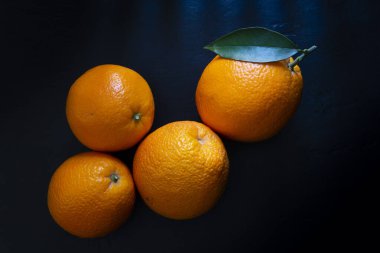 Siyah arkaplanda dört portakal