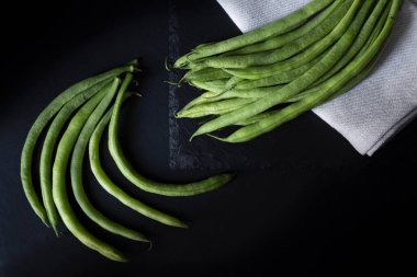 Yuvarlak fasulye, bez peçete ve siyah arka plan.