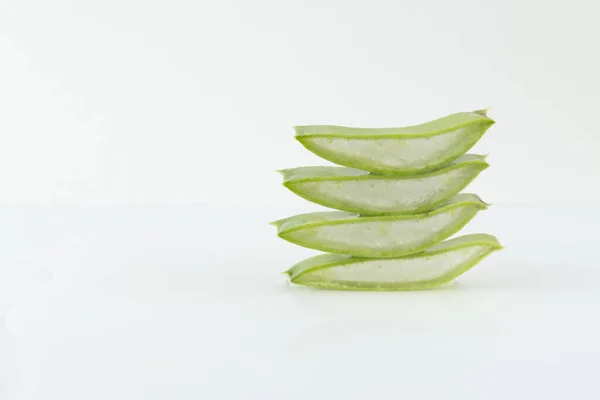 Dilimlenmiş aloe vera yaprakları beyaz arkaplanda