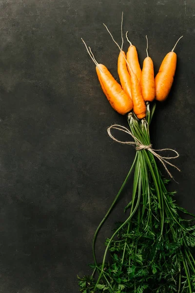 Siyah bir arka plan üzerinde olgunlaşmış havuç demet