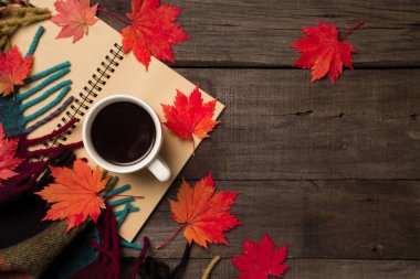 Sonbahar yaprakları ve bir fincan kahve ile ekose eski vintage ahşap arka plan üzerinde.