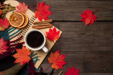 Sonbahar yaprakları ve bir fincan kahve ile ekose eski vintage ahşap arka plan üzerinde.