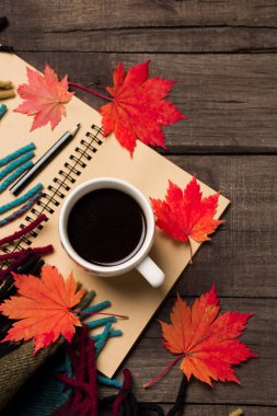Sonbahar yaprakları ve bir fincan kahve ile ekose eski vintage ahşap arka plan üzerinde.