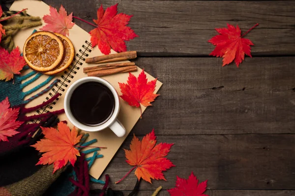 Sonbahar yaprakları ve bir fincan kahve ile ekose eski vintage ahşap arka plan üzerinde.