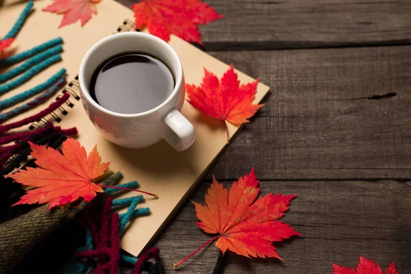 Sonbahar yaprakları ve bir fincan kahve ile ekose eski vintage ahşap arka plan üzerinde.
