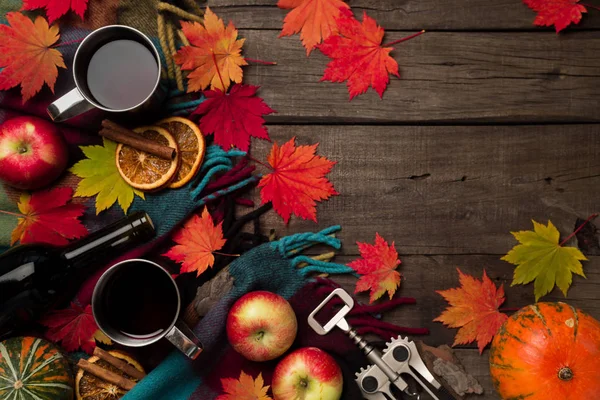 Sonbahar yaprakları, iki bardak şarap, Kırmızı elma ile ekose eski vintage ahşap arka plan üzerinde.