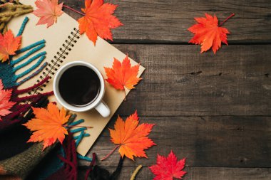 Sonbahar yaprakları ve bir fincan kahve ile ekose eski vintage ahşap arka plan üzerinde.
