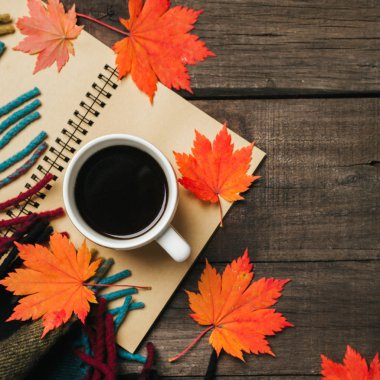 Sonbahar yaprakları ve bir fincan kahve ile ekose eski vintage ahşap arka plan üzerinde.