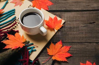 Sonbahar yaprakları ve bir fincan kahve ile ekose eski vintage ahşap arka plan üzerinde.