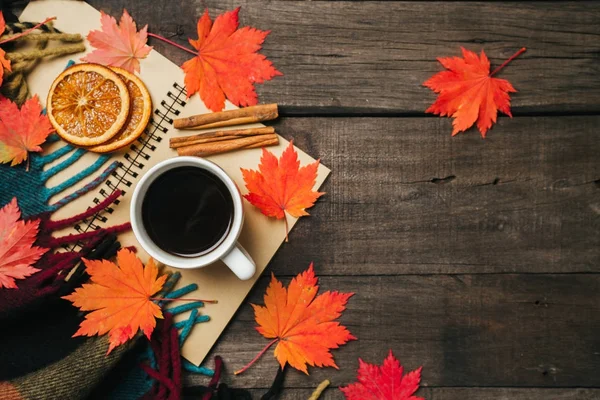 Folhas de outono e uma xícara de café com xadrez no velho fundo de madeira vintage . — Fotografia de Stock