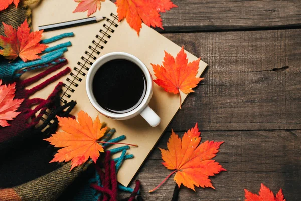 Sonbahar yaprakları ve bir fincan kahve ile ekose eski vintage ahşap arka plan üzerinde.