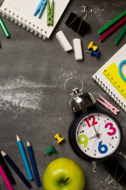 Geri için okul kavramı saat renk tebeşir kalem apple dizüstü üzerinden kara tahta arka plan ile. Uzay kopyalayın. Üstten Görünüm. Düz yatıyordu