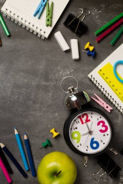 Geri için okul kavramı saat renk tebeşir kalem apple dizüstü üzerinden kara tahta arka plan ile. Uzay kopyalayın. Üstten Görünüm. Düz yatıyordu