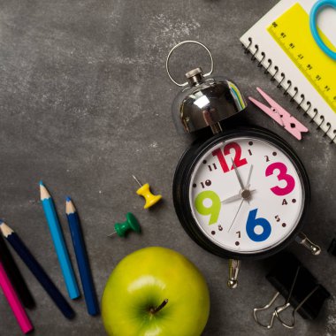 Geri için okul kavramı saat renk tebeşir kalem apple dizüstü üzerinden kara tahta arka plan ile. Uzay kopyalayın. Üstten Görünüm. Düz yatıyordu