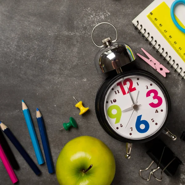 Geri için okul kavramı saat renk tebeşir kalem apple dizüstü üzerinden kara tahta arka plan ile. Uzay kopyalayın. Üstten Görünüm. Düz yatıyordu