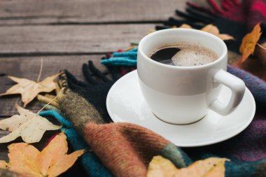 Ekose yaprakları ve bir fincan kahve eski vintage ahşap arka plan üzerinde sıcak sonbahar kompozisyonu.