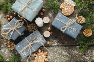 Festival hediye kutuları, mum, kar, iğne yapraklı, sepet, tarçın, çam kozalakları, deli ahşap arka plan üzerinde.