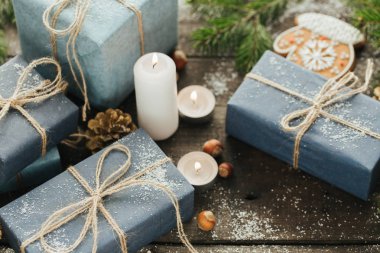 Festival hediye kutuları, mum, kar, iğne yapraklı, sepet, tarçın, çam kozalakları, deli ahşap arka plan üzerinde.