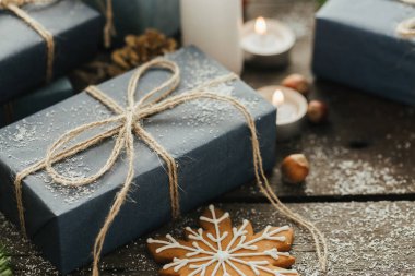 Festival hediye kutuları, mum, kar, iğne yapraklı, sepet, tarçın, çam kozalakları, deli ahşap arka plan üzerinde.