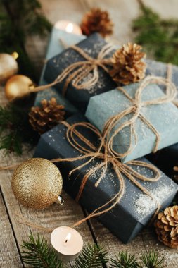 Festival hediye kutuları, mum, kar, iğne yapraklı, sepet, tarçın, çam kozalakları, deli ahşap arka plan üzerinde.