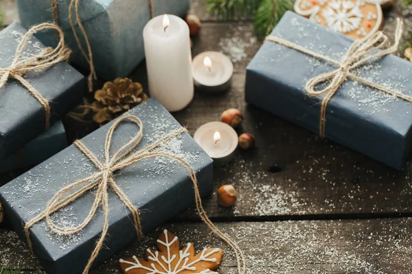 Святкові подарунки з коробки, Свічка, сніг, хвойні, кошик, кориця, Пайн-конусів, гайки на фоні дерев'яні. — стокове фото