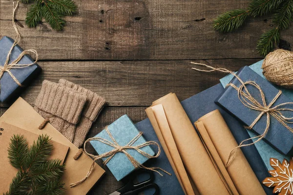 Упаковка різдвяних подарунків у старовинному бежево-блакитному рулонному папері на старому дерев'яному столі. Вид зверху. Плоска лежала. Копіювати простір . — стокове фото