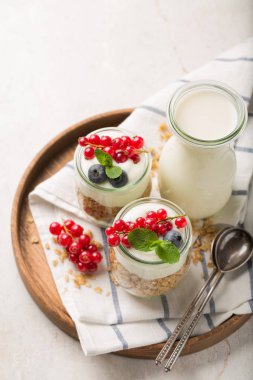 Yoğurt, granola, süt ve beyaz arka plan üzerinde meyveleri ile kahvaltı. Sağlıklı gıda kavramı. Sağlıklı kahvaltı madde