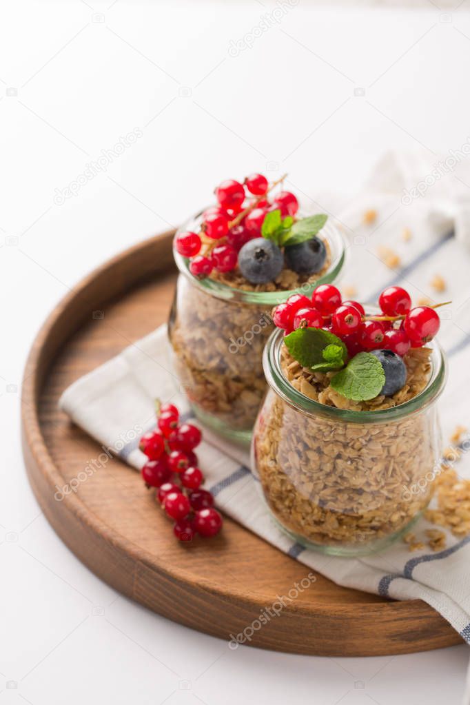 Homemade granola with berries on white background