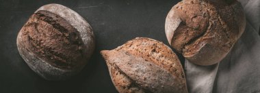 Düz-lay çeşitli ekmek seçimi. Mutfak havlu gri arka plan, üstten görünüm, kopya alanı tahıllı rustik ekmek