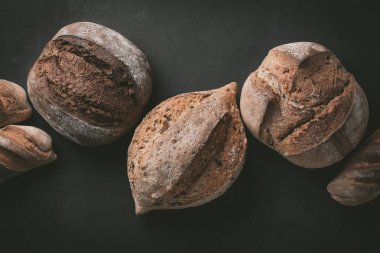 Çeşitli seçim düz-lay ekmek. Tahıllı rustik ekmek gri arka plan üzerine. Görünümü en çok, uzay kopyalayın. Yatay kompozisyon