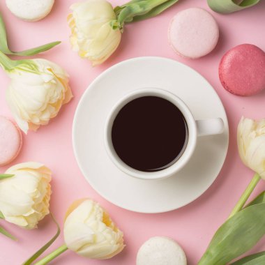 Bahar sabah kavramı. Düz-lay fincan kahve beyaz çiçekler ve macarons üzerinde açık pembe renkli, sizin metin için yer ile Üstten Görünüm