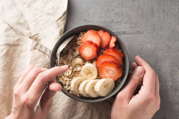 Gesunde Frühstücksschüssel essen. Müsli und frisches Obst in Keramikschüssel in Frauenhänden. Clean Eating, Diät, Detox, vegetarisches Ernährungskonzept. — Stockfoto