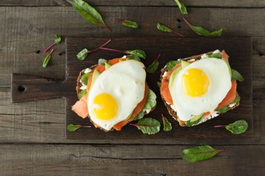 Sağlıklı kahvaltı. Ekmek tost peynir, kızarmış yumurta, Balık ve taze sebzelerin üzerine ahşap arka plan, görünümü top. Diyet, kilo kaybı gıda kavramı