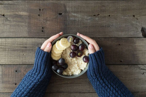 Gesundes Frühstück. graue Schale mit Haferbrei und Früchten in Frauenhänden. Ernährungskonzept — Stockfoto