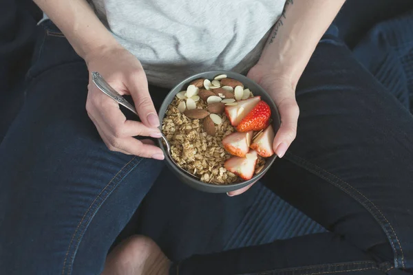 Gesundes Frühstück. graue Keramikschale mit Müsli, Erdbeere und Nüssen in Frauenhand. Ernährungs- und vegetarisches Ernährungskonzept — Stockfoto