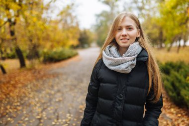 Parkta sonbahar sezonunda bir güzel, tatlı, neşeli kız portresi