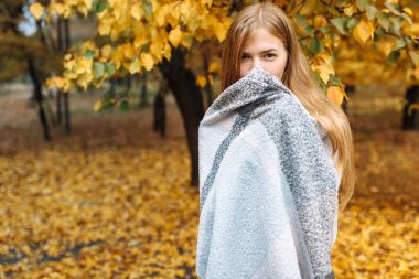 Parkta sonbahar sezonunda bir güzel, tatlı, neşeli kız portresi