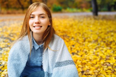 Parkta sonbahar sezonunda bir güzel, tatlı, neşeli kız portresi
