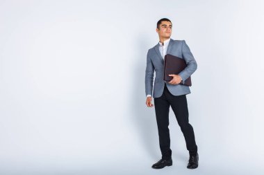 Bir menüyü, beyaz arka plan üzerinde Studio elbiseli şık iş adam okuyan klasör adamla yakışıklı adam