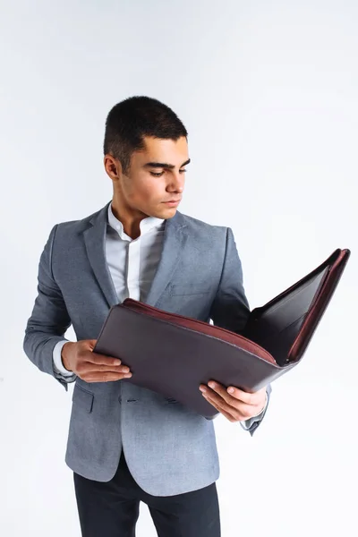 Hombre guapo con carpeta hombre leyendo un menú, un hombre de negocios con estilo en traje en Studio sobre fondo blanco — Foto de Stock