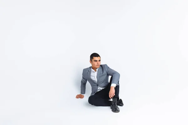 Porträt der Schönen posiert in einem Studio, weißer Hintergrund, stilvoller Geschäftsmann, stilvoller Mann sitzt — Stockfoto