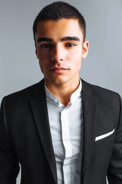 Joven guapo en un traje elegante, posando sobre un fondo blanco aislado — Foto de Stock