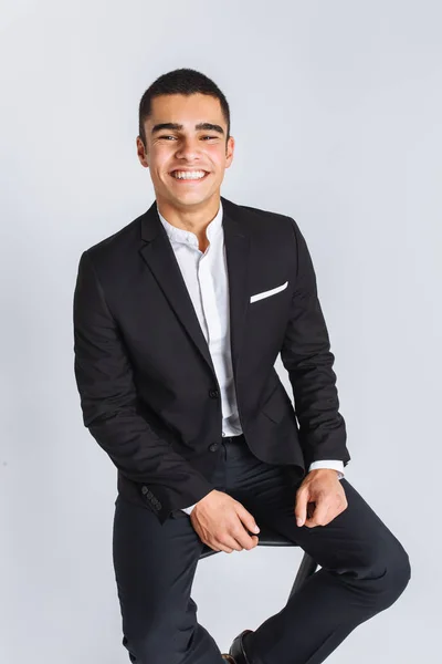 Retrato da bela posando em um estúdio, fundo branco, homem de negócios elegante, homem elegante sentado em uma cadeira de designer — Fotografia de Stock