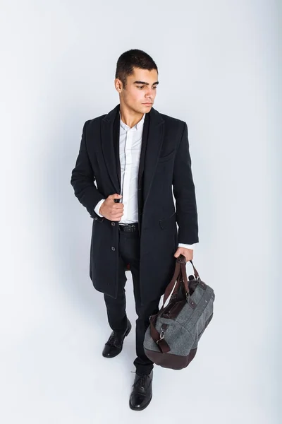 Elegante hombre en el estudio sobre un fondo blanco, con una bolsa para viajar, aislado, fondo, el hombre va en un viaje — Foto de Stock